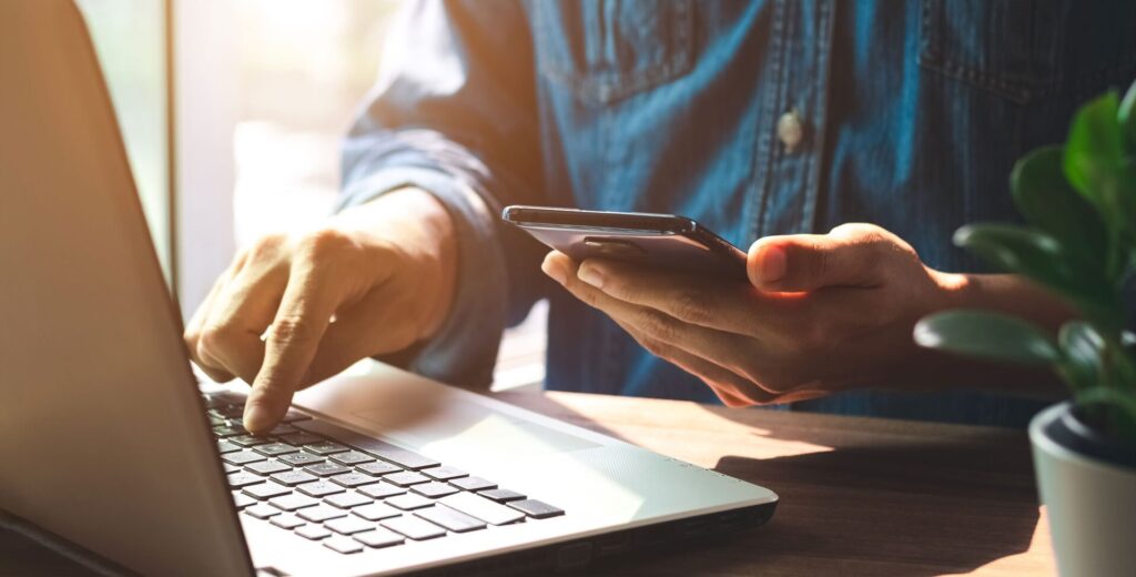 Picture of a patient contacting the dental office using his computer and his phone.